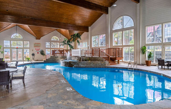 a large swimming pool in a building with large windows