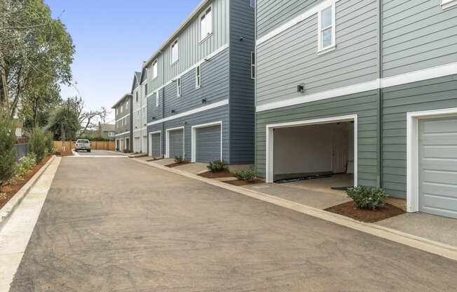 an empty parking lot in front of a building with a garage door open