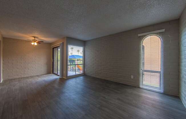 an empty living room with wood flooring and a large window