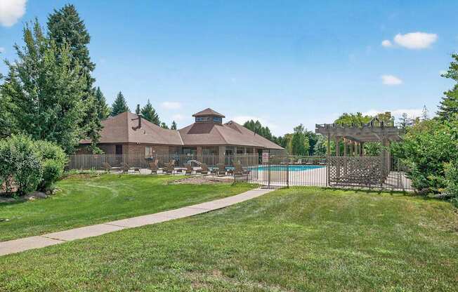 A house with a brown roof and a pool in the backyard.