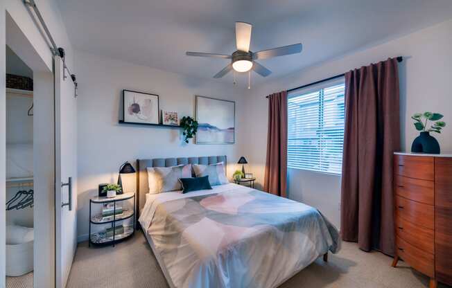 a bedroom with a bed and a ceiling fan