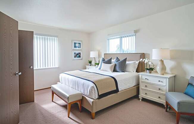 A bedroom with a bed, nightstand, and chair.