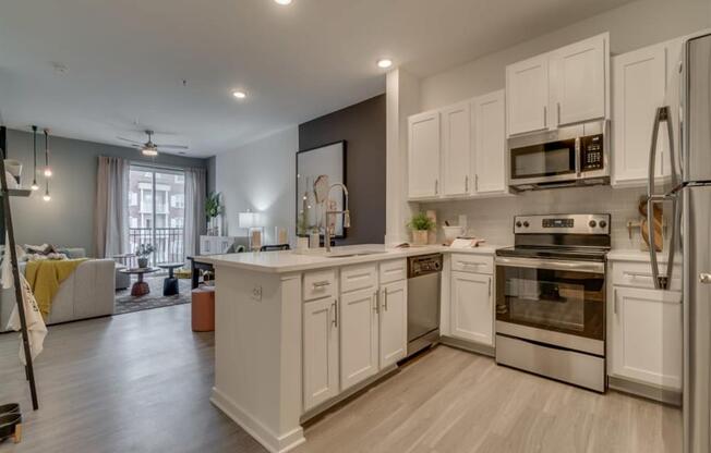 a large kitchen with white cabinets and stainless steel appliances at Flats at West Broad Village, Virginia, 23060