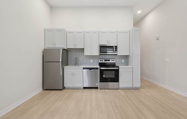 A kitchen with white cabinets and stainless steel appliances.