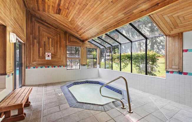 A wooden ceiling over a hot tub in a room.