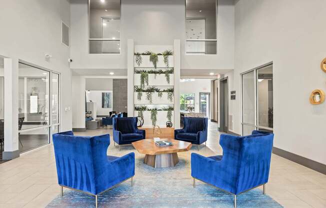A living room with blue chairs and a rug.