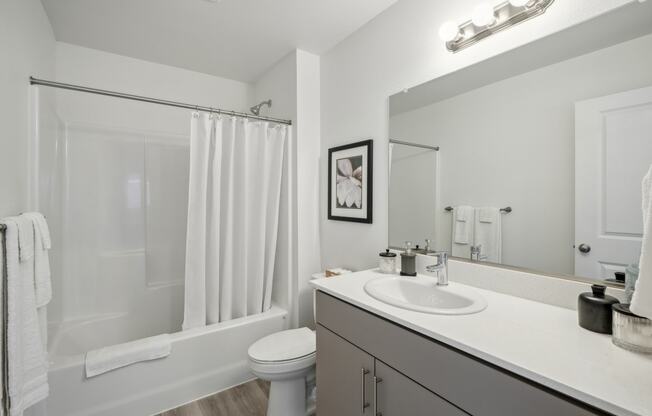 a bathroom with a large mirror and a shower and a toilet