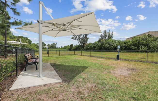 a park bench sitting under an umbrella in a yard