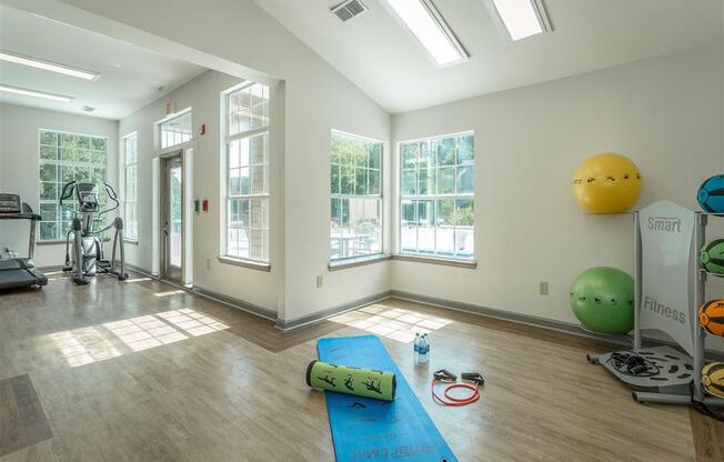 a workout room with yoga mats and a gym ball on the wall