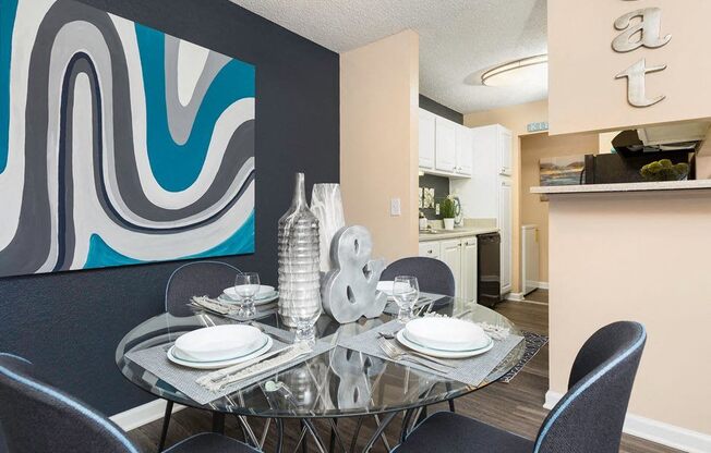 a dining room with a glass table and chairs