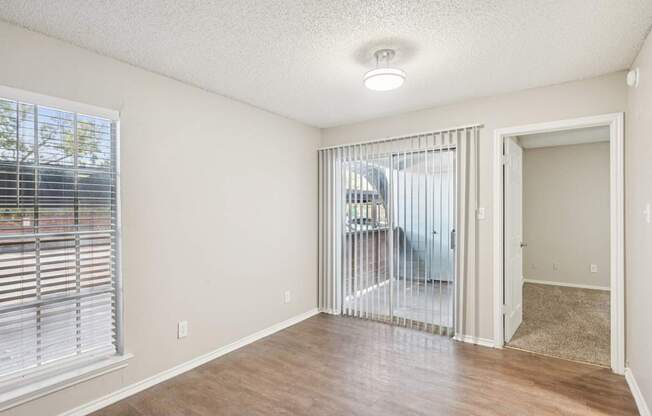 A room with a sliding glass door leading to a balcony.