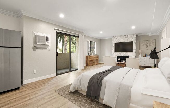 A bedroom with a large bed and a television on the wall.