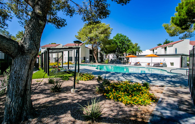 a swimming pool with trees and buildings in the background