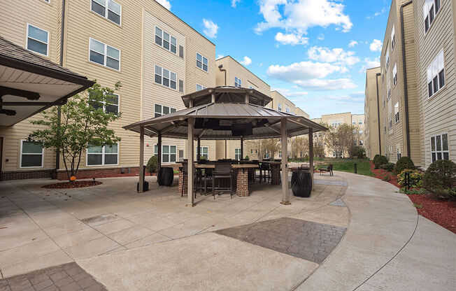 a patio with a table and chairs in front of a building