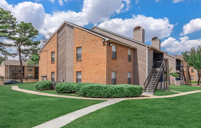 a large lawn in front of a brick building