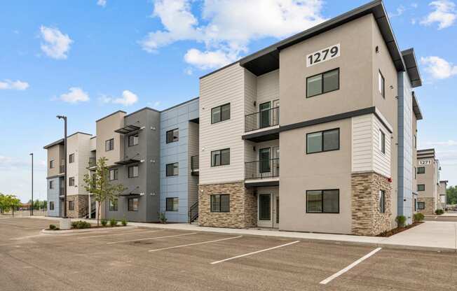 modern apartment buildings with a parking lot and a blue sky