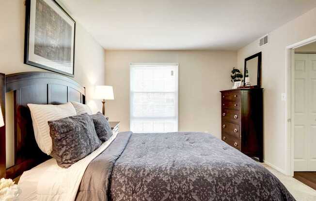 A bedroom with a large bed and a painting on the wall.
