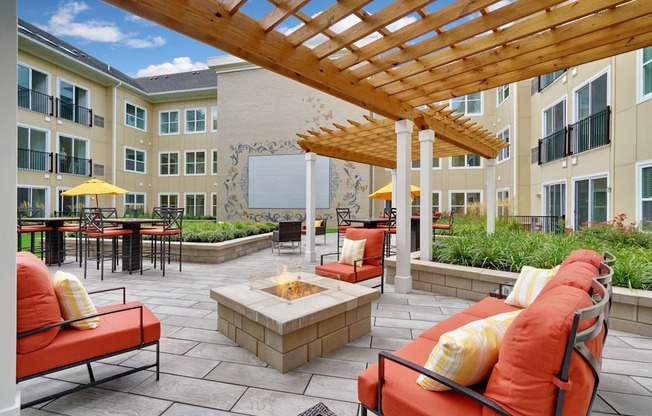an outdoor patio with couches and chairs and a fire pit