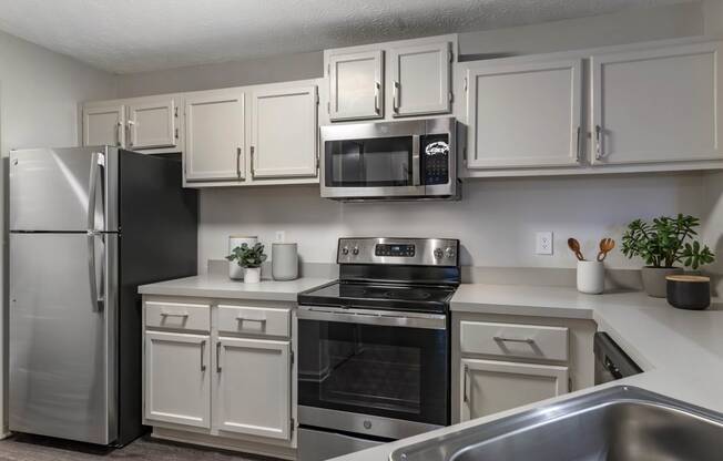 a kitchen with stainless steel appliances and white cabinets at Gwinnett Pointe, Norcross, Georgia