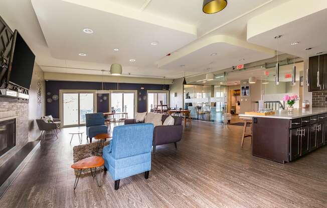 A modern living room with a fireplace and a kitchen area.