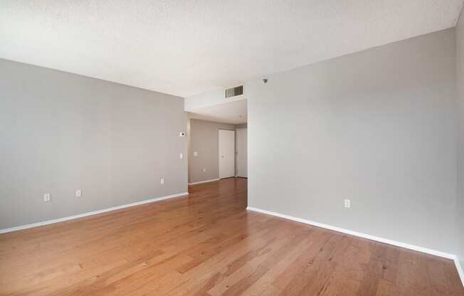 the living room and dining room of an apartment with wood flooring