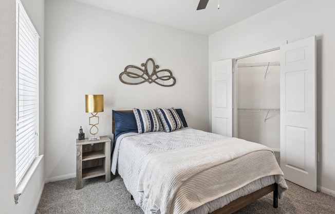 B3 bedroom with a bed, nightstand, and a ceiling fan at Creekside on Parmer Lane Apartments in Austin, TX