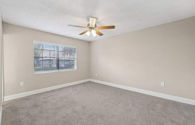A room with a ceiling fan and a window.