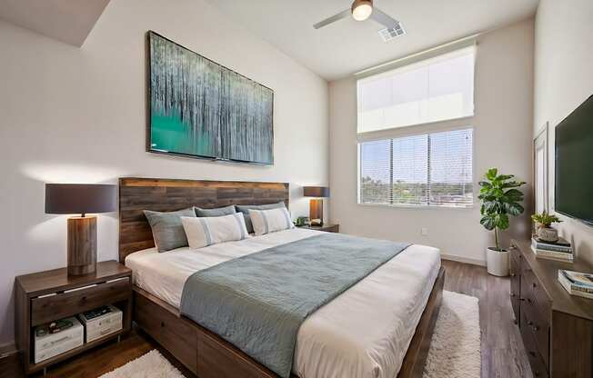 A bedroom with a large bed and a painting above it.