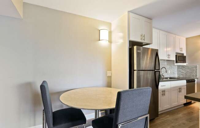 Dining area with wood inspired floors and kitchen in the right