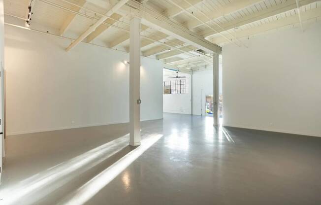 an empty room with white walls and a concrete floor