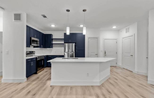 a white kitchen with a large island and black cabinets