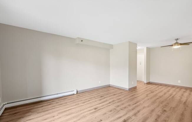 an empty living room with wood flooring and white walls