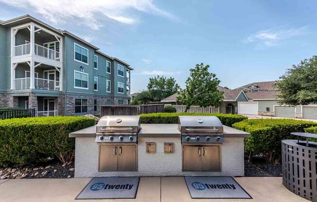 A bbq grill is in front of a building with a sign that says "twenty".