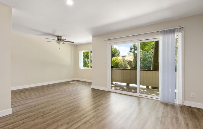 a living room with a sliding glass door and a ceiling fan