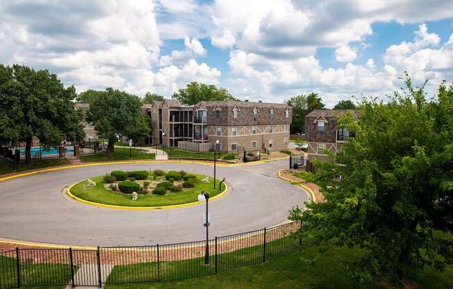 A large building with a circular garden in front of it.