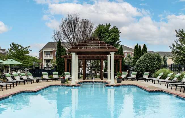 a swimming pool with a gazebo and chairs around it