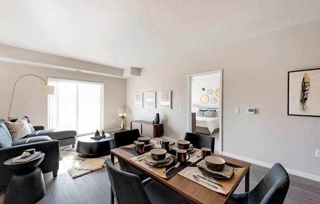 A modern dining room with a wooden table set for four.