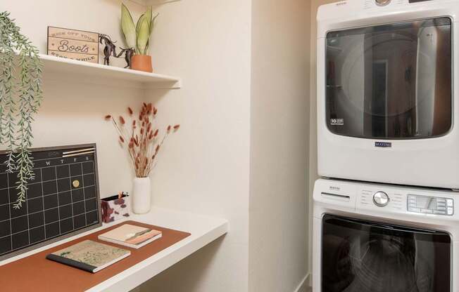 A modern kitchen with a white oven and a wooden shelf.