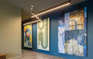 Three paintings hang on a wall in a room.