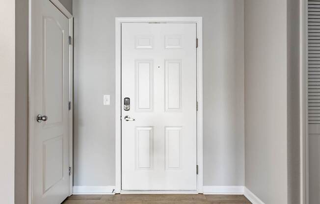 A white door with a black handle and lock in a room.