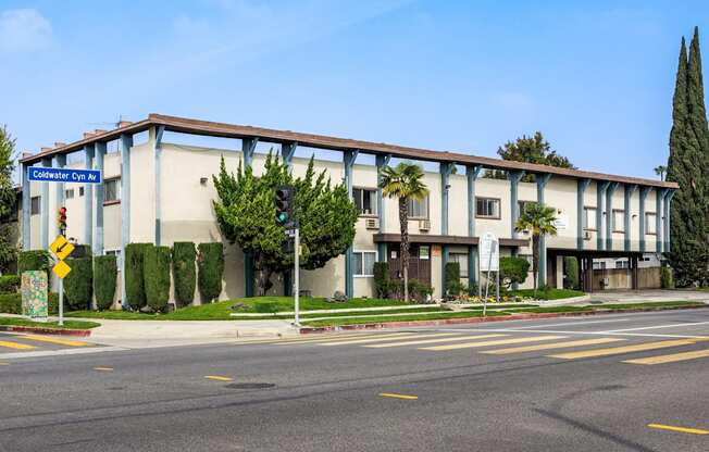 a large building with palm trees in front of it on a street