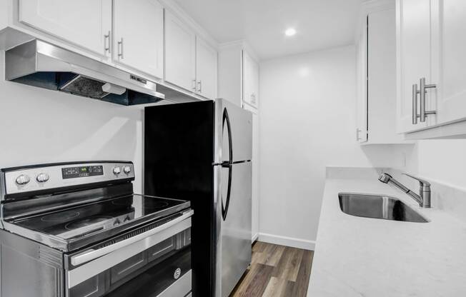 a kitchen with white cabinets and stainless steel appliances