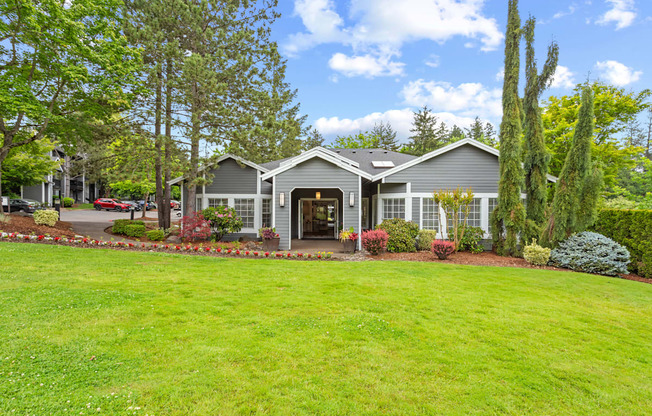 A house with a grey roof and a green lawn in front.
