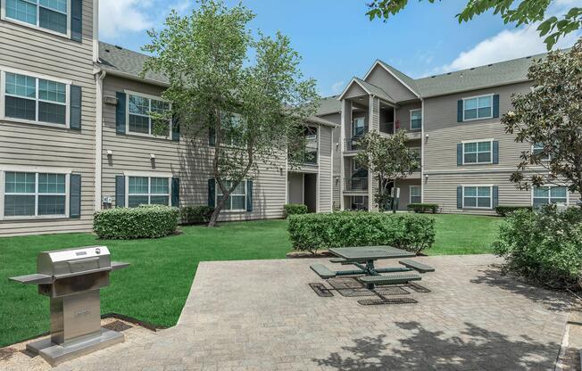 BARBECUE AREA WITH LUSH GREEN LANDSCAPING IN PORT ARTHUR, TX