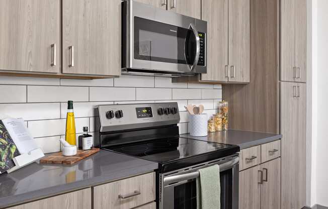 a kitchen with stainless steel appliances and wooden cabinets at Palm Grove in Ellenton, FL 34222