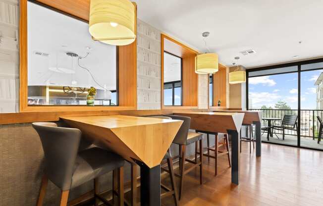a dining area with wooden tables and chairs and a large window with a view of the outdoors