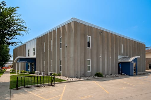 a large metal building with a parking lot in front of it