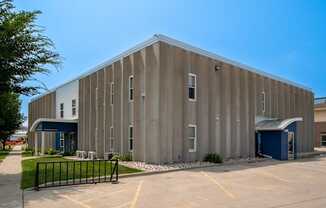 a large metal building with a parking lot in front of it