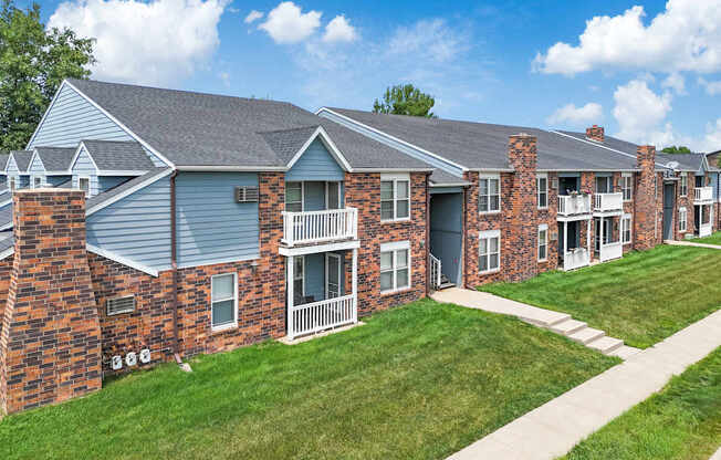 A row of red brick houses with white balconies.