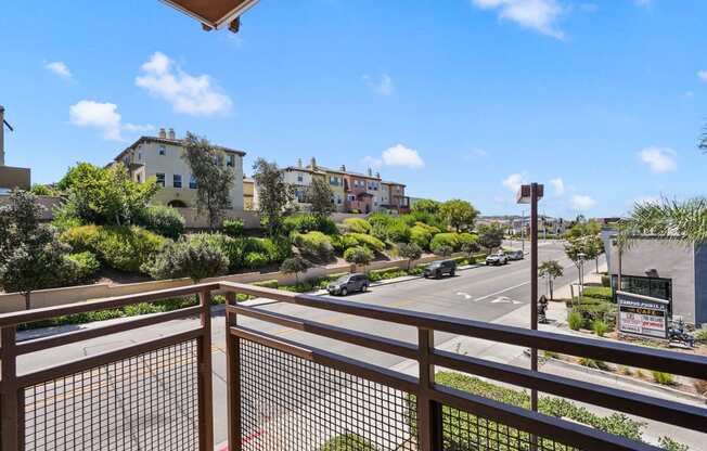 a view of the street from a balcony with a fence